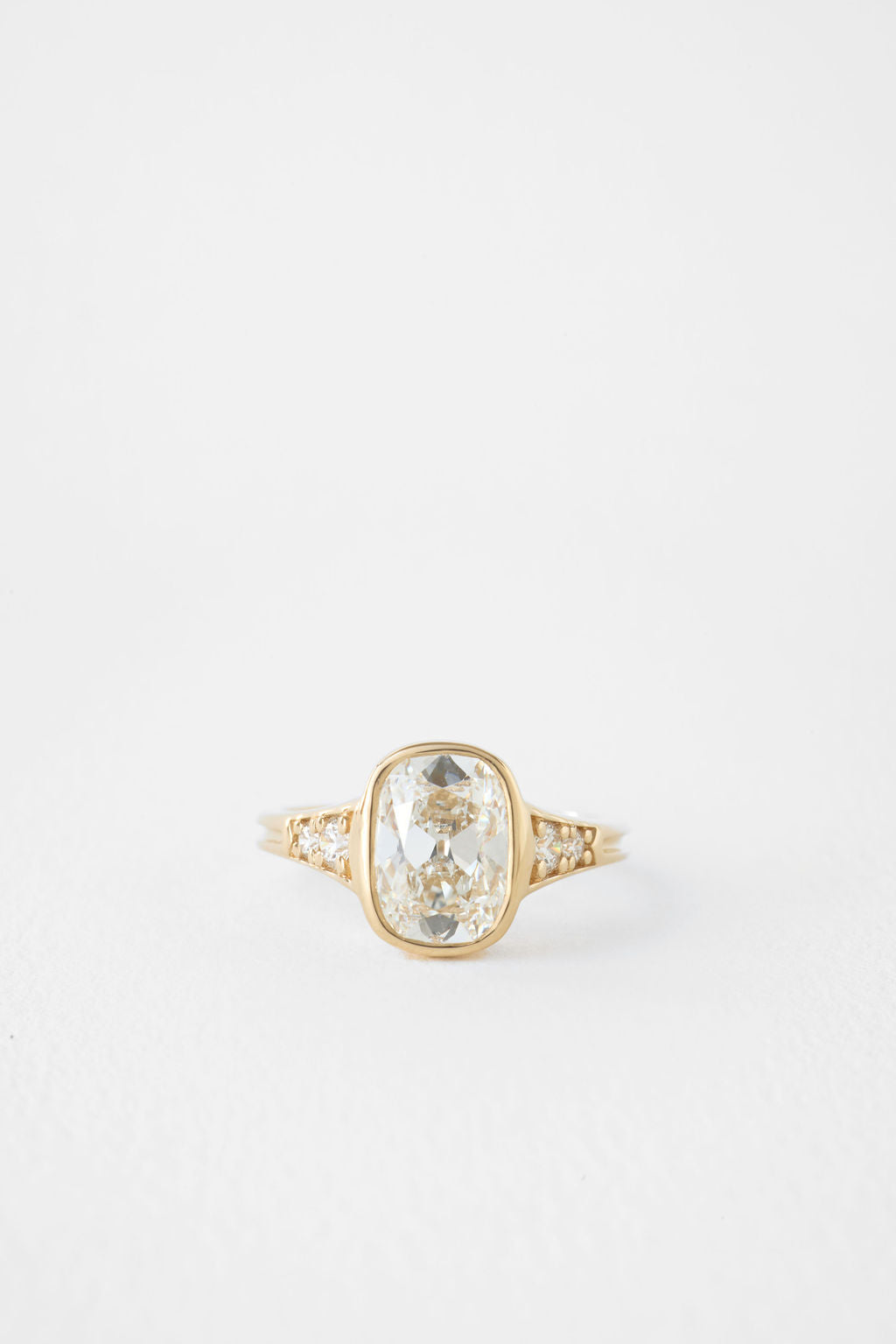 Antique cushion cut lab grown diamond bezel ring with graduated shoulders in yellow gold