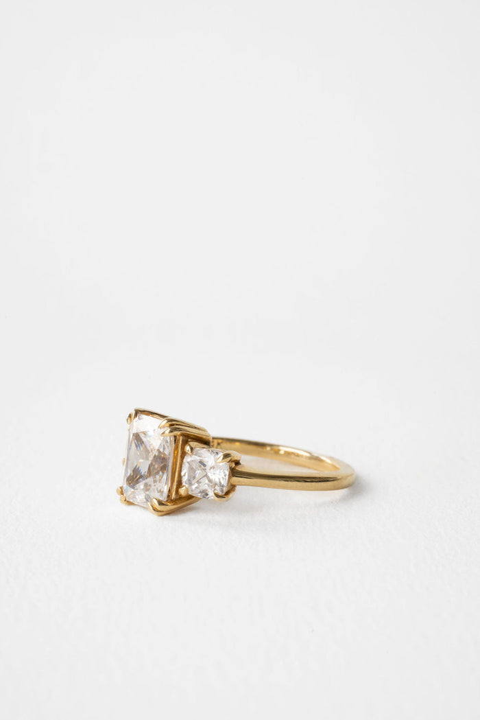 Angled view of the radiant cut diamond between its trapezoid side stones