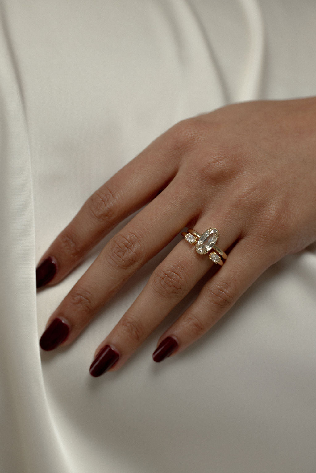 Oval lab grown diamond open shank wedding band in yellow gold stacked with an engagement ring