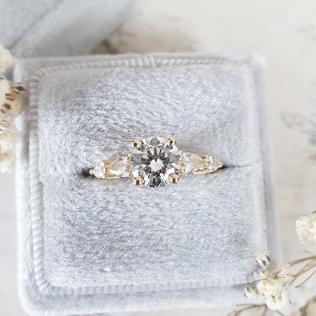 Round cut lab grown diamond five stone ring with pear and round sides in yellow gold