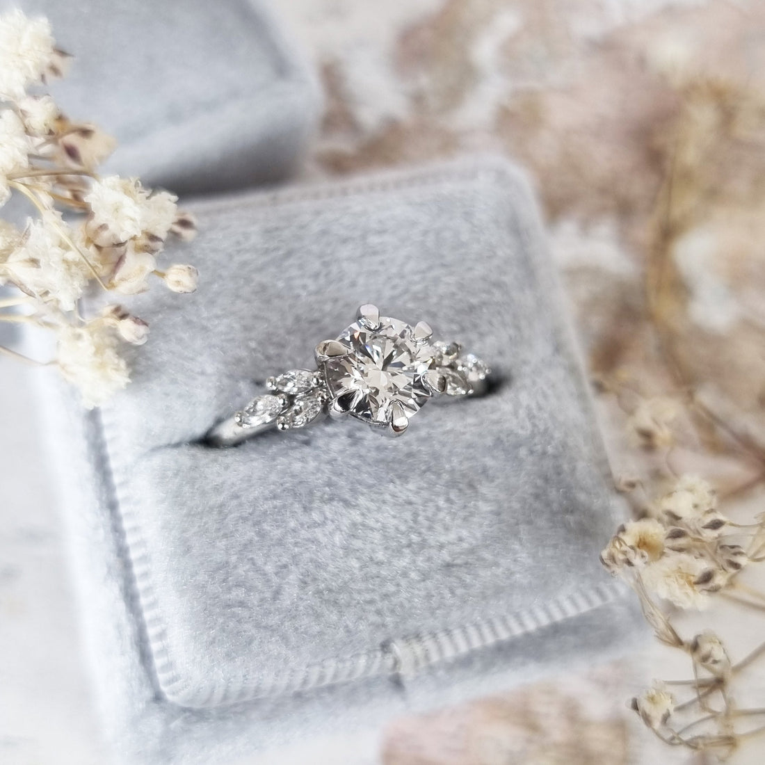Round cut lab grown diamond ring with marquise leaf shoulders in white metal