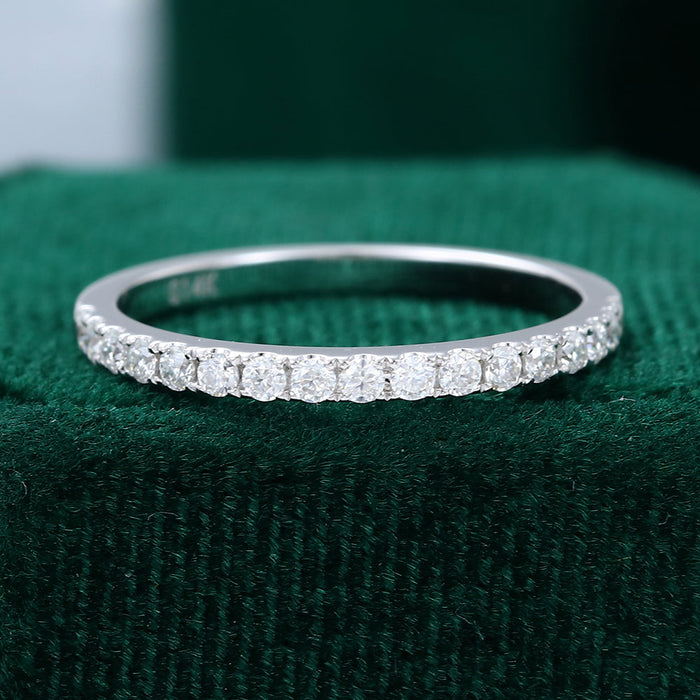 Front view of a thin white gold wedding band with a row of French pave set round moissanite stones