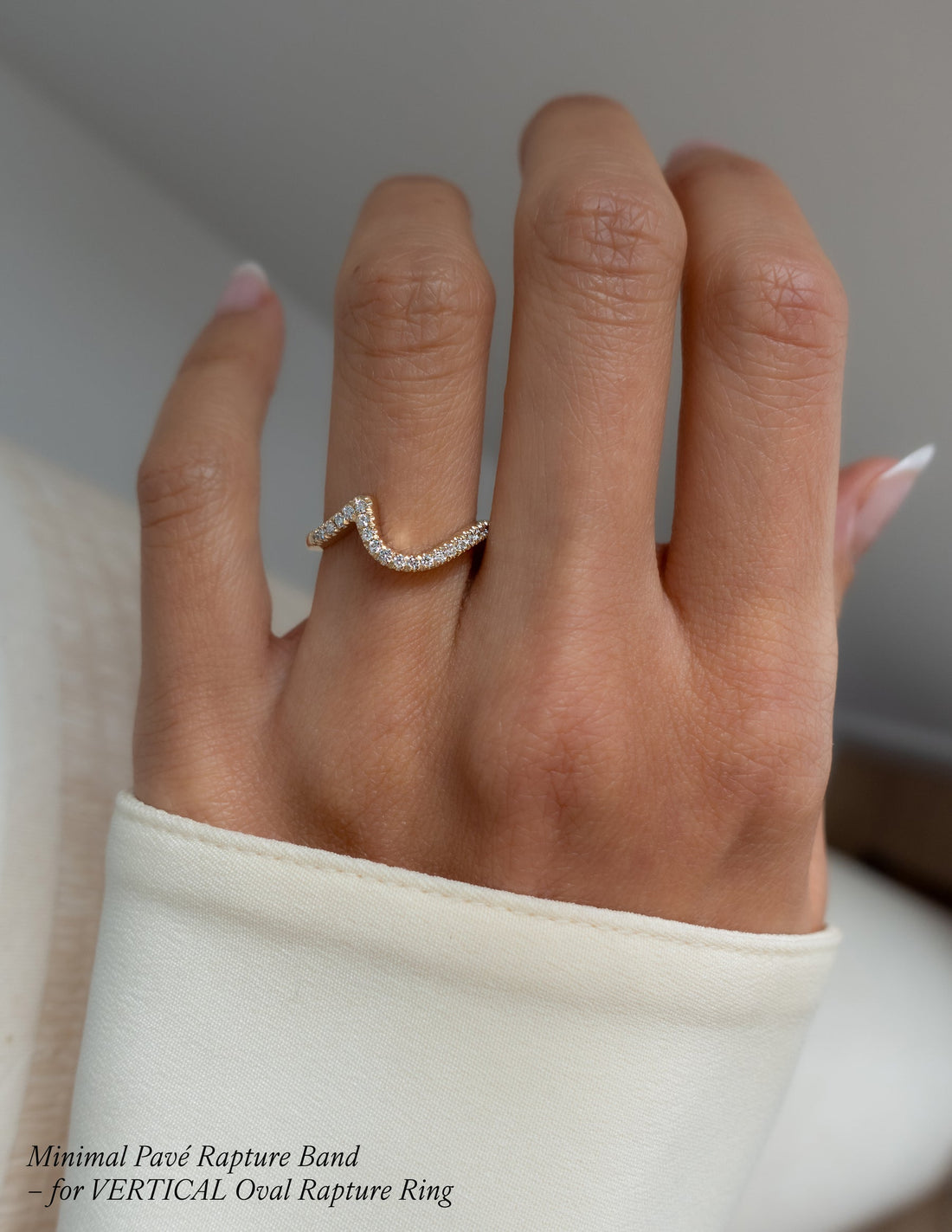 Curved wave pave wedding band with round moissanite worn on the ring finger