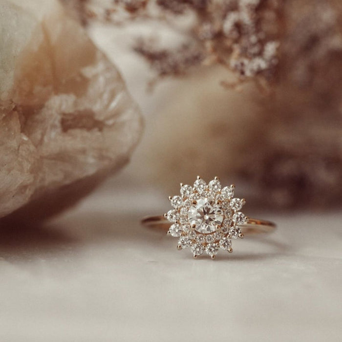 Round cut moissanite starburst halo engagement ring in 14K gold