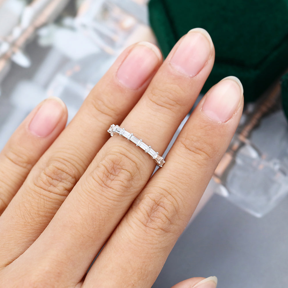 Baguette moissanite prong half eternity wedding band worn on a finger