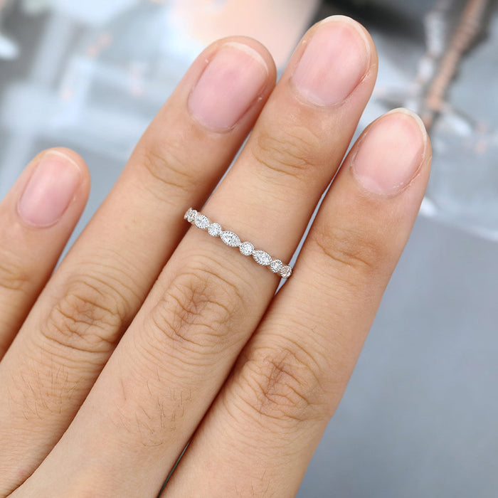 Marquise and round moissanite milgrain half eternity wedding band worn on a finger