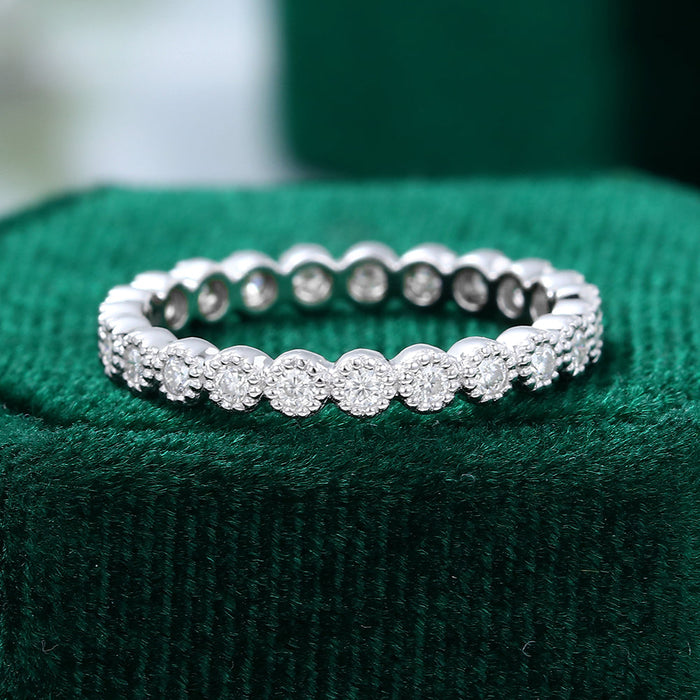 Front view of a white gold full eternity wedding band with round moissanite stones in milgrain frames