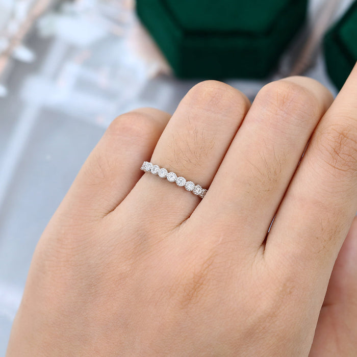 Round moissanite milgrain bezel full eternity wedding band in white gold worn on the finger