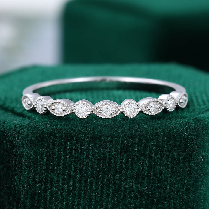 Front view of a white gold vintage wedding band with round moissanite stones in beaded milgrain frames