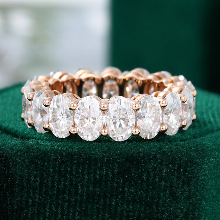 Front view of an oval moissanite full eternity wedding band in rose gold with large prong set ovals