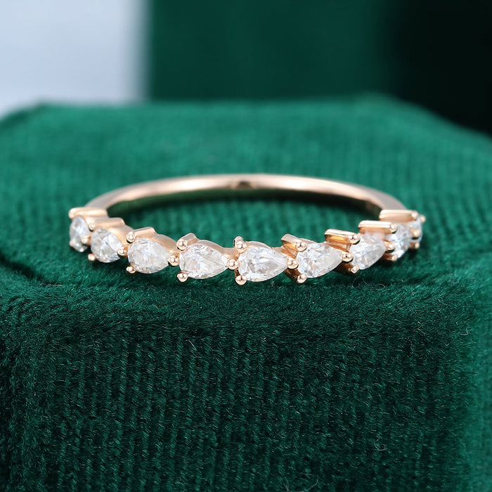 Front view of a pear moissanite half eternity wedding band in rose gold with prong set pear stones