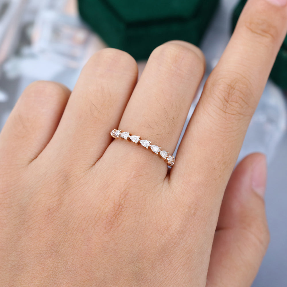 Pear moissanite half eternity wedding band in rose gold worn on the finger