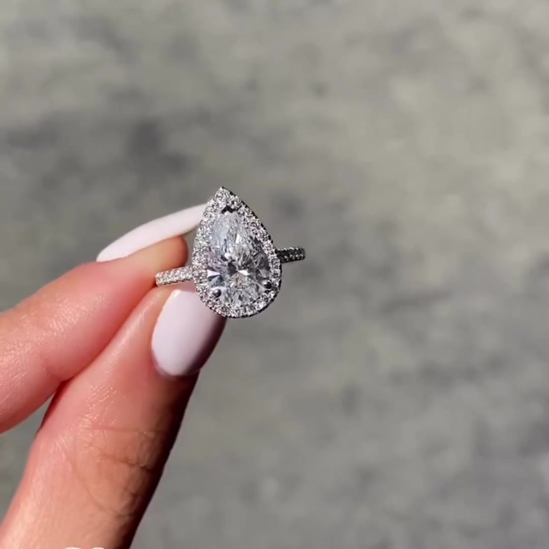 Pear cut moissanite engagement ring with diamond halo in 14K gold