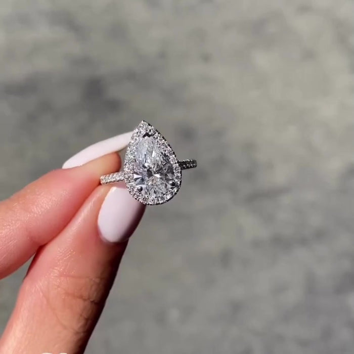 Pear cut moissanite engagement ring with diamond halo in 14K gold