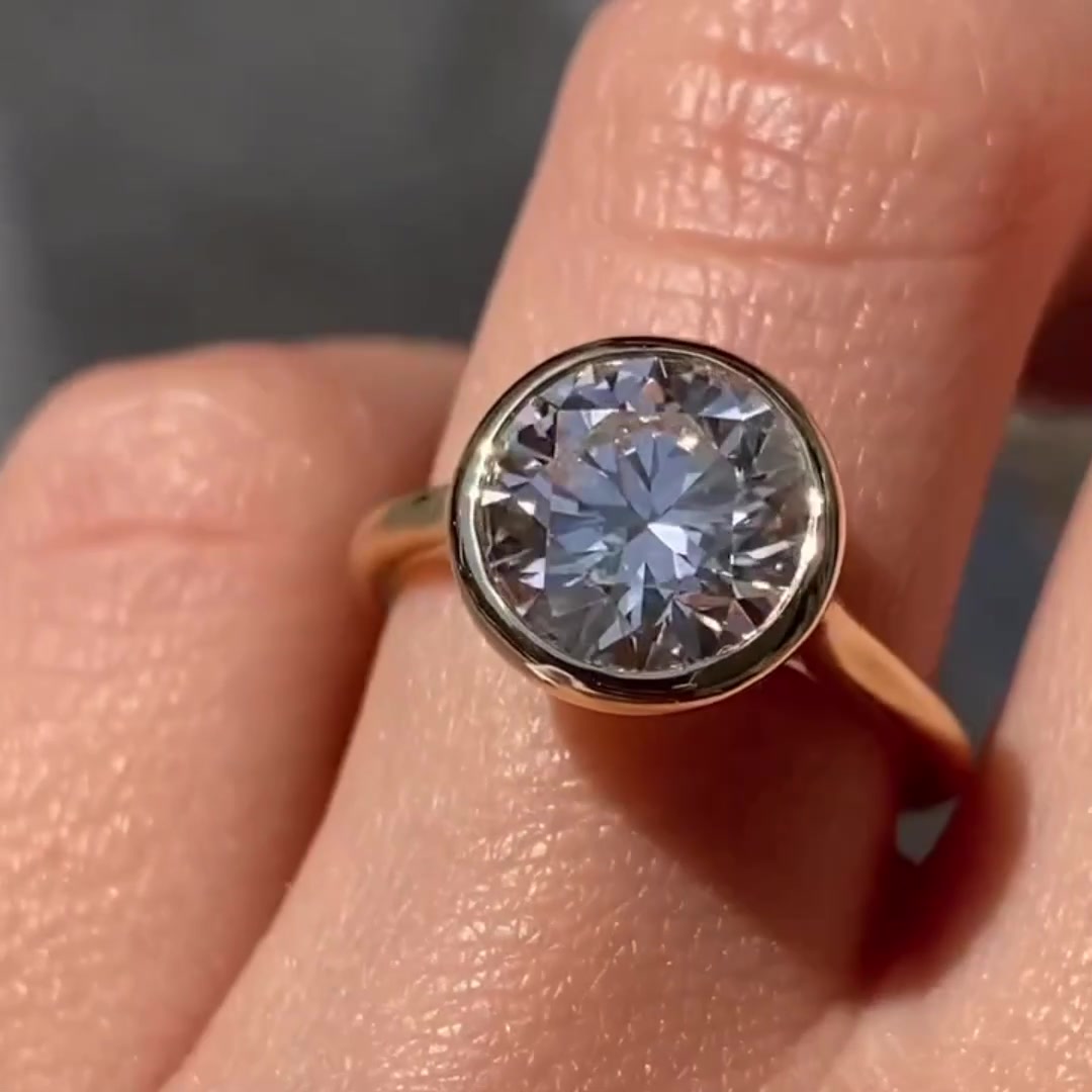 Bezel set round cut moissanite engagement ring in 14K gold