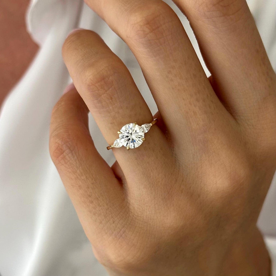 Round cut lab grown diamond three stone ring with pear cut side stones