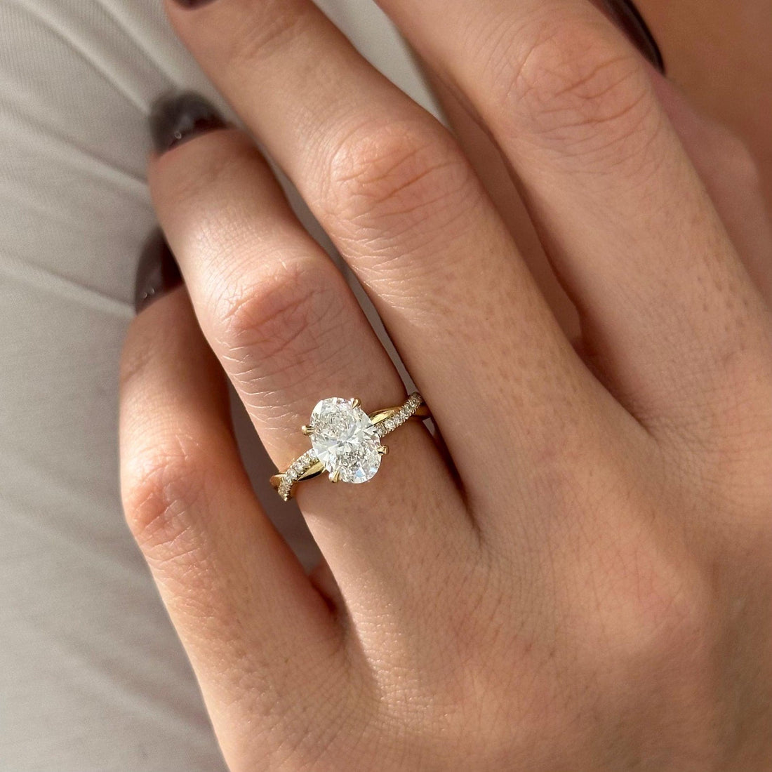 Oval cut lab grown diamond solitaire ring with twisted pave band