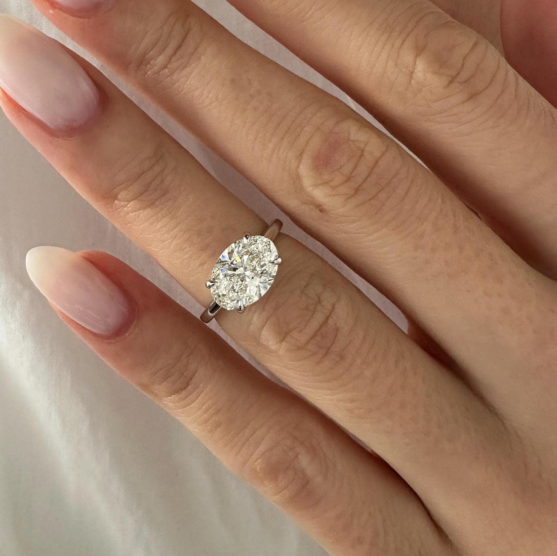 East west oval cut lab grown diamond cathedral solitaire ring