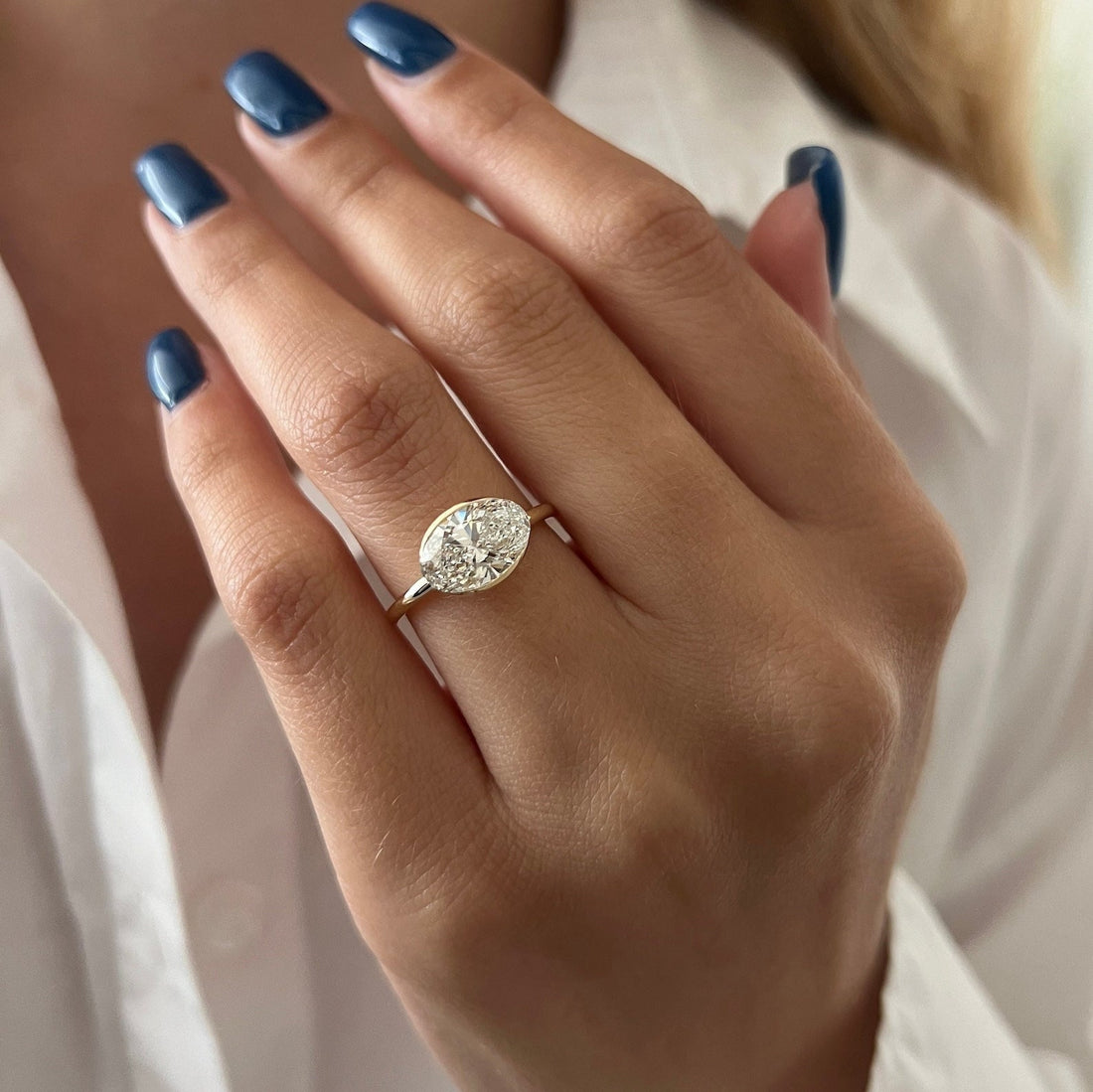 Low profile east west oval lab grown diamond bezel wrap ring with hidden halo