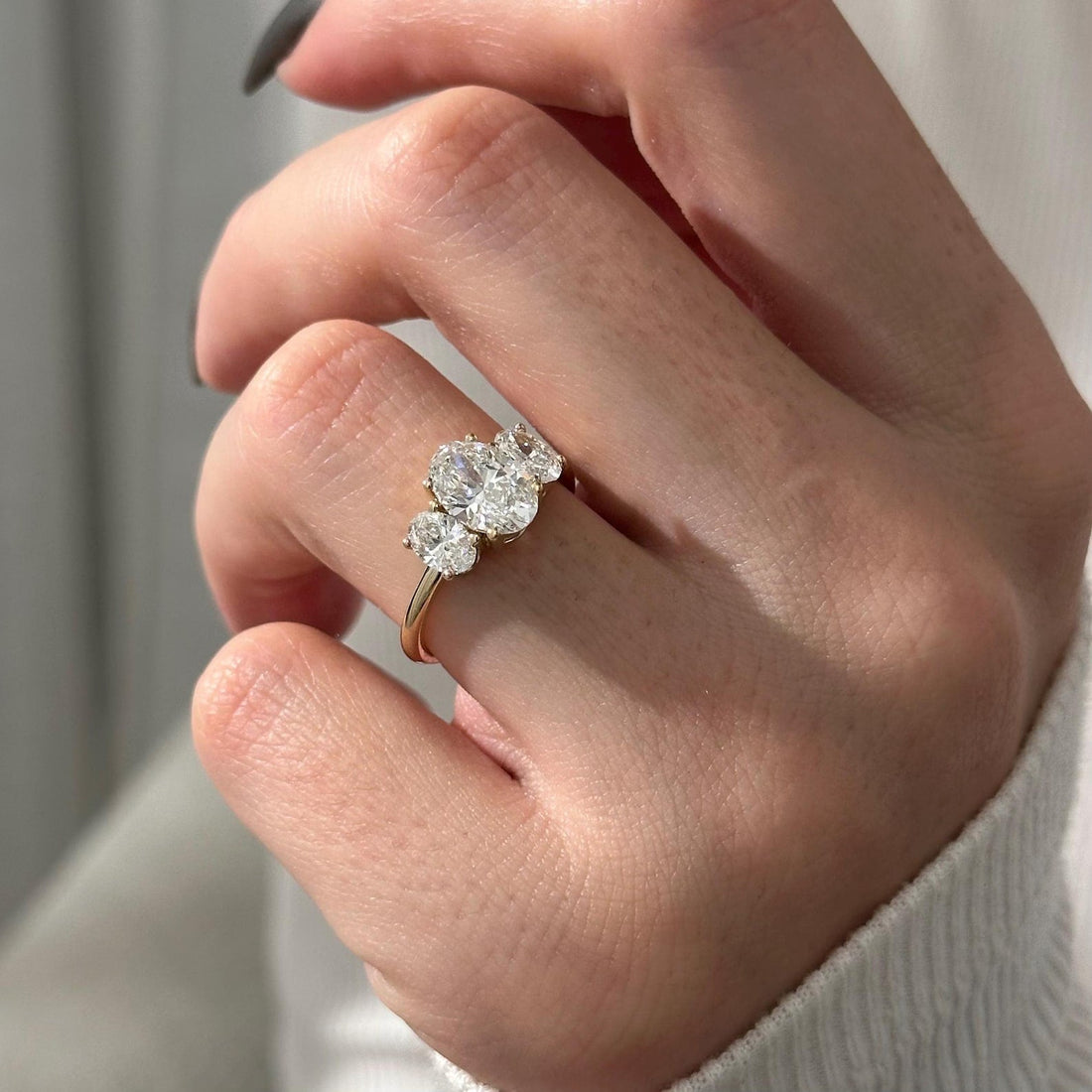 Oval cut lab grown diamond three stone ring with oval side stones