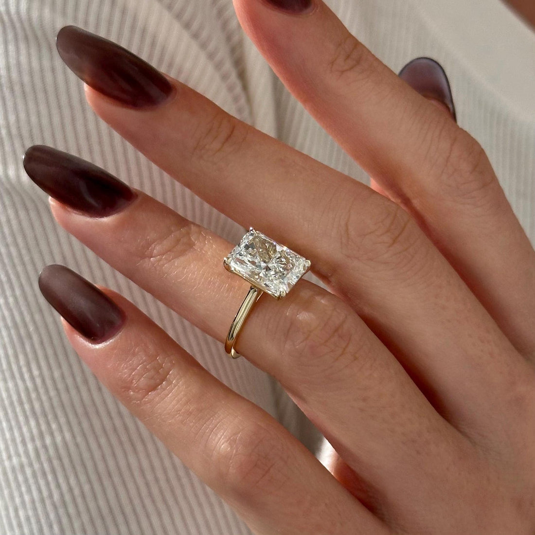 Elongated radiant cut lab grown diamond solitaire ring on a thin band