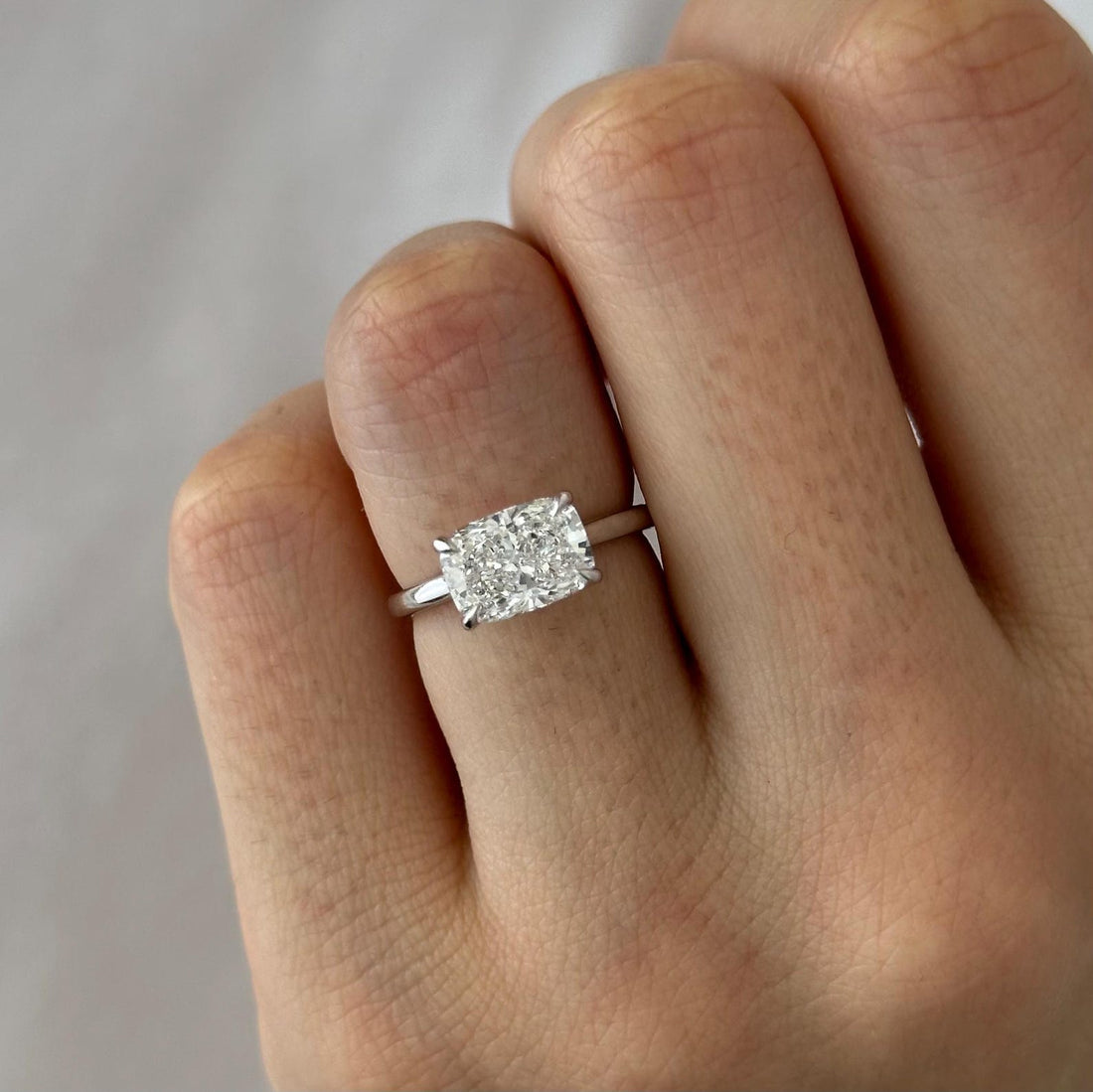East west elongated cushion cut lab grown diamond claw set solitaire ring