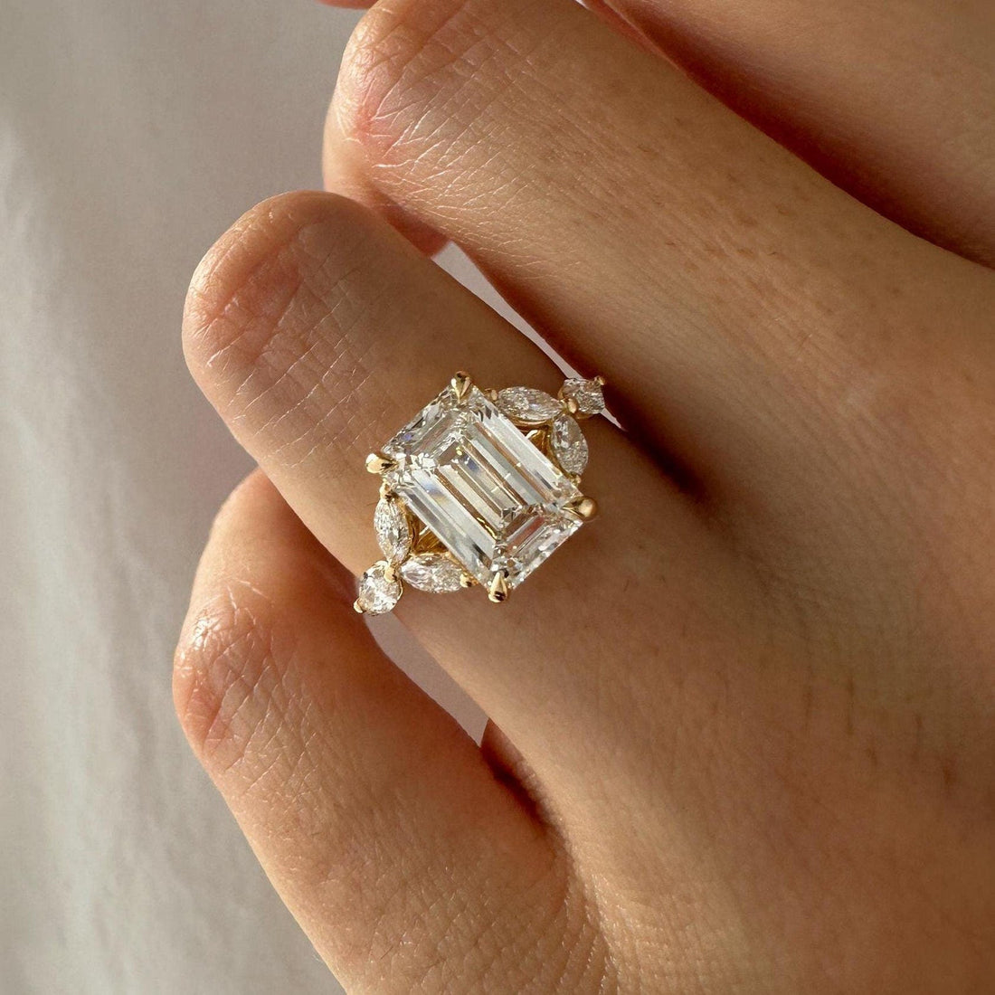 Emerald cut lab grown diamond ring with marquise cluster halo and pave band