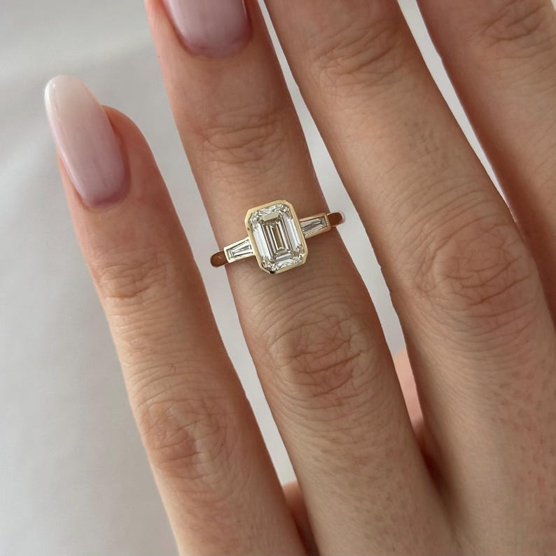 Emerald cut lab grown diamond stepped bezel ring with flush set baguettes