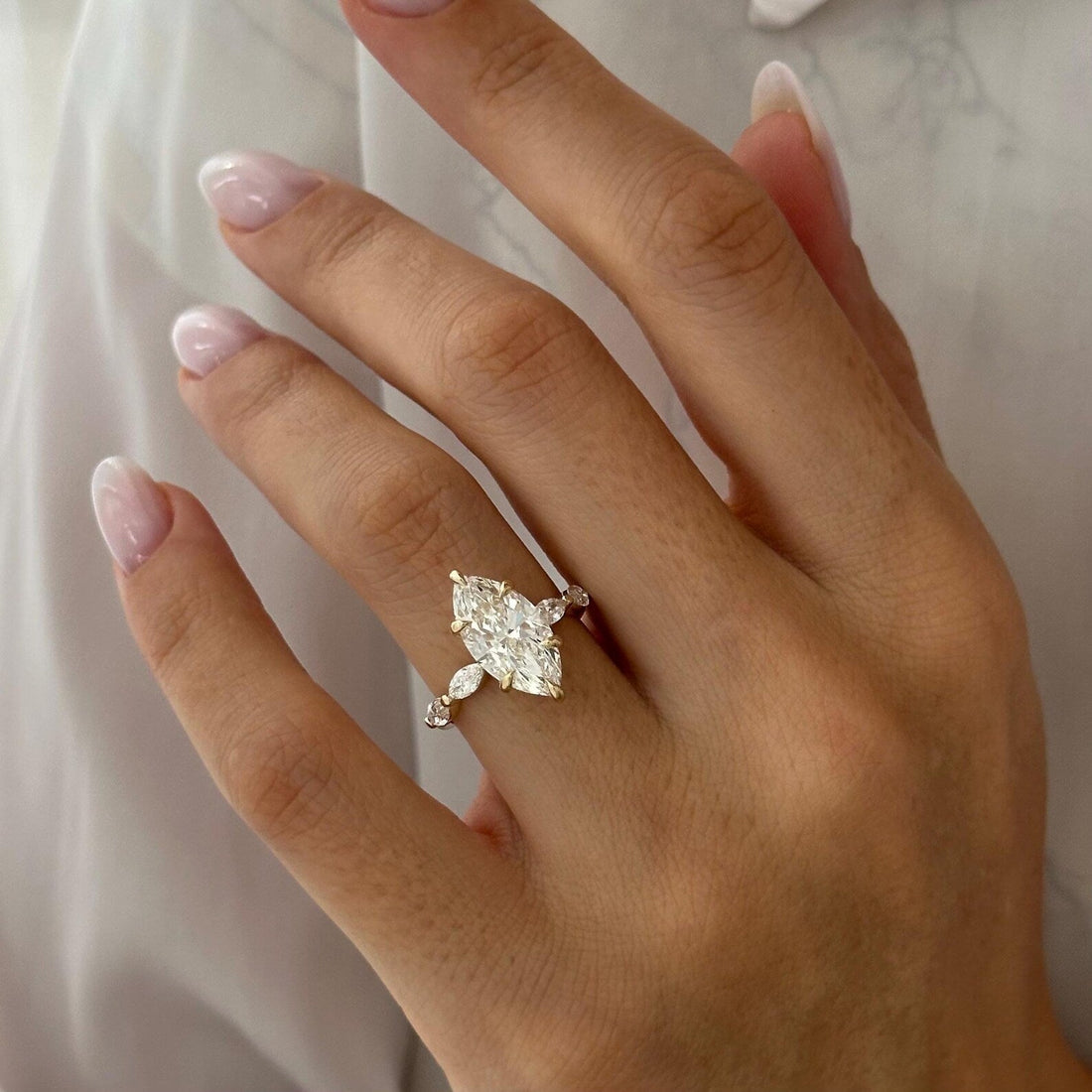 Marquise cut lab grown diamond ring with marquise and round accent band
