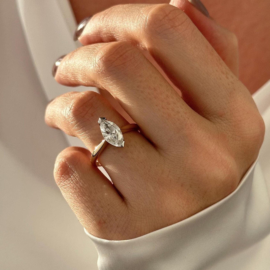 Low profile marquise cut lab grown diamond solitaire ring on a flat yellow gold band