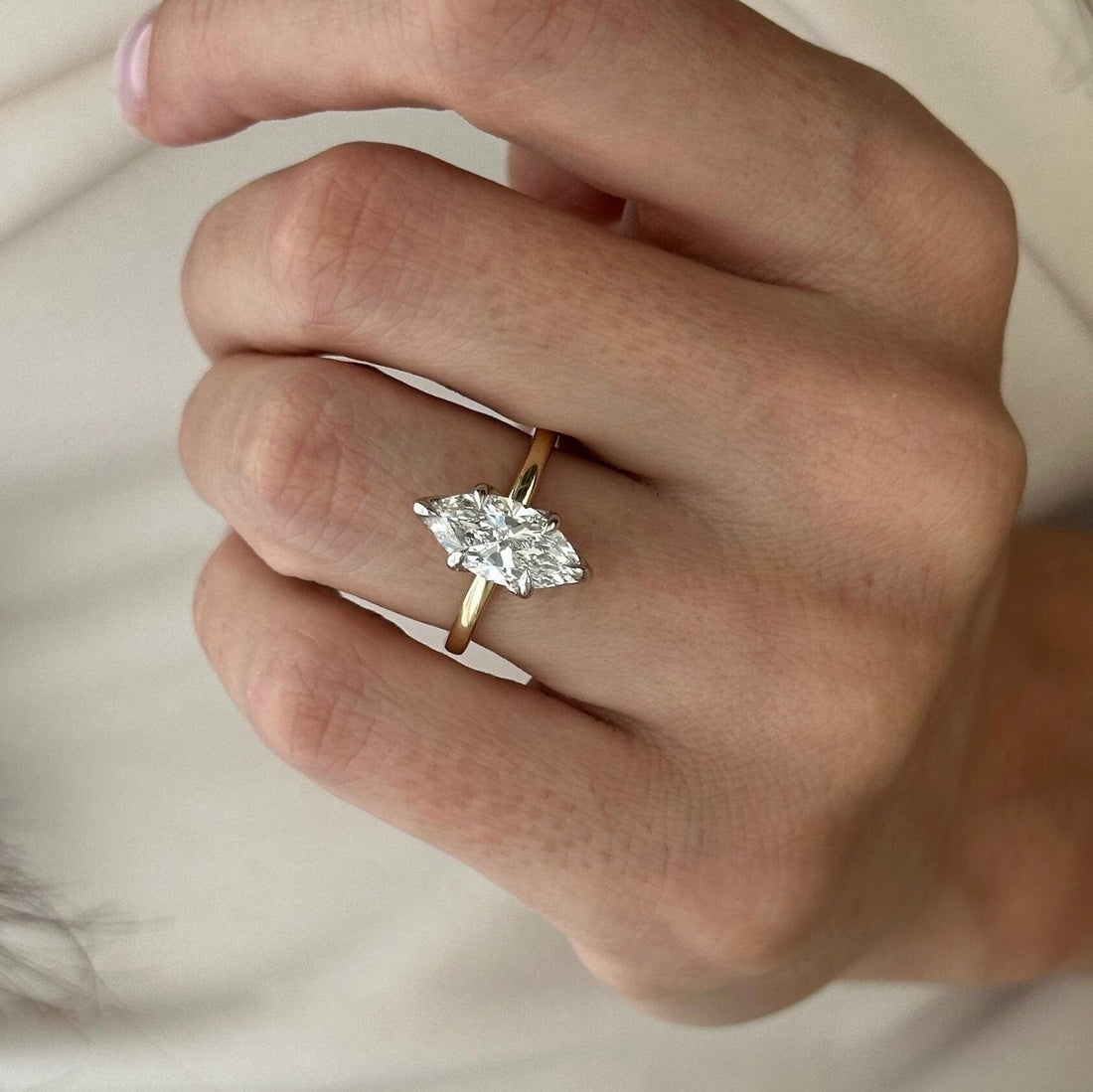 Marquise cut lab grown diamond hidden halo ring on a tapered thin yellow gold band