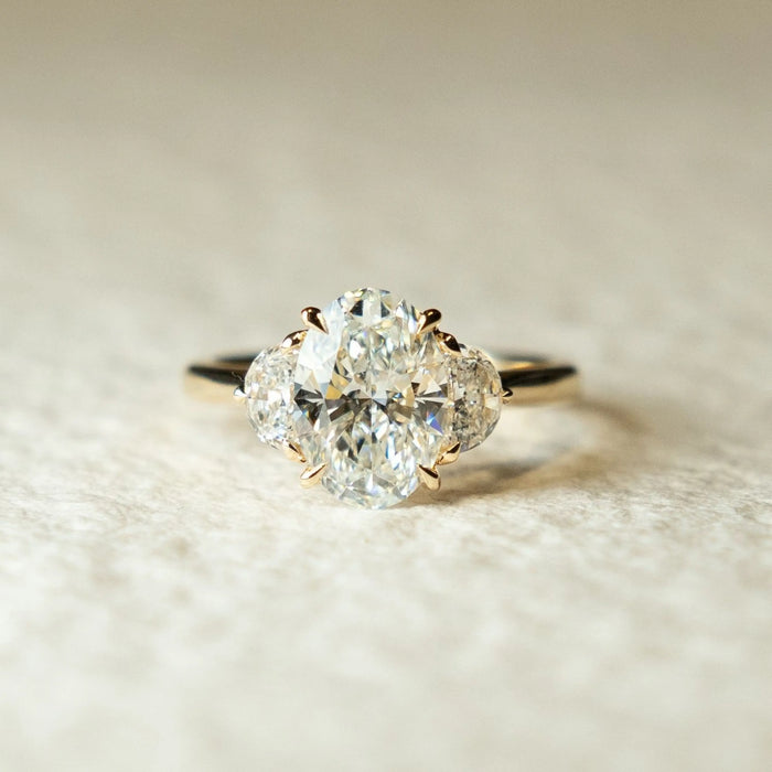 Oval cut moissanite and diamond three stone engagement ring in gold