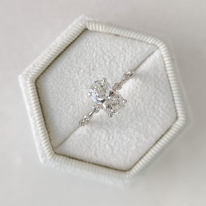 Oval cut lab grown diamond ring with spaced accent diamonds along the band