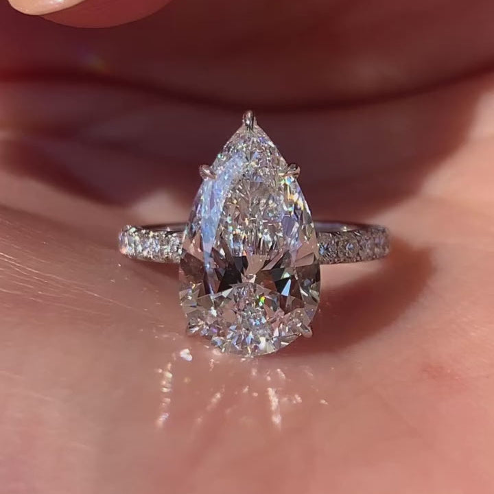 Pear shaped moissanite hidden halo engagement ring in solid gold
