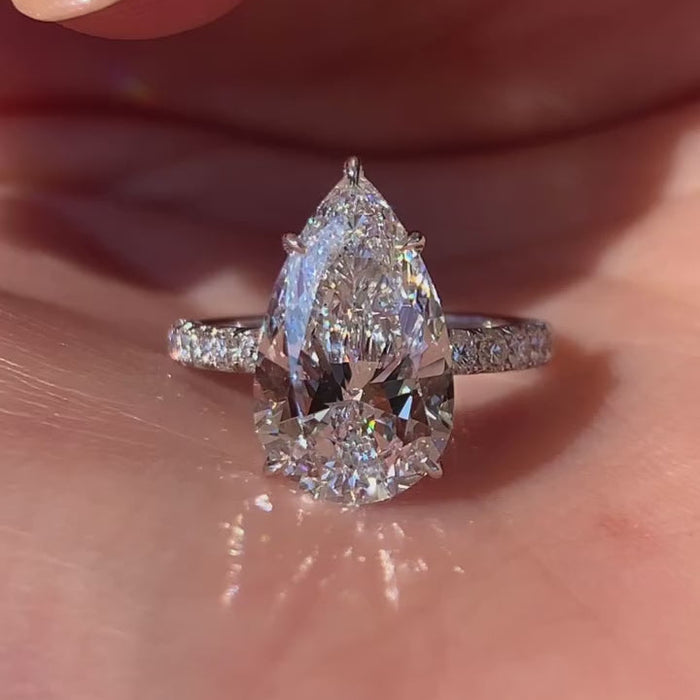 Pear shaped moissanite hidden halo engagement ring in solid gold