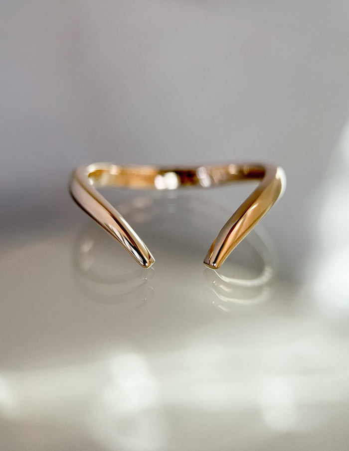 Plain gold open V wedding band with a gap between the tapered ends