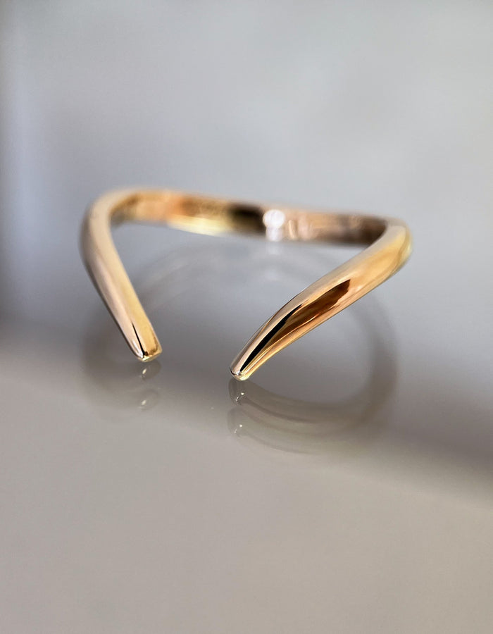 Plain gold open V wedding band with tapered ends, front angle