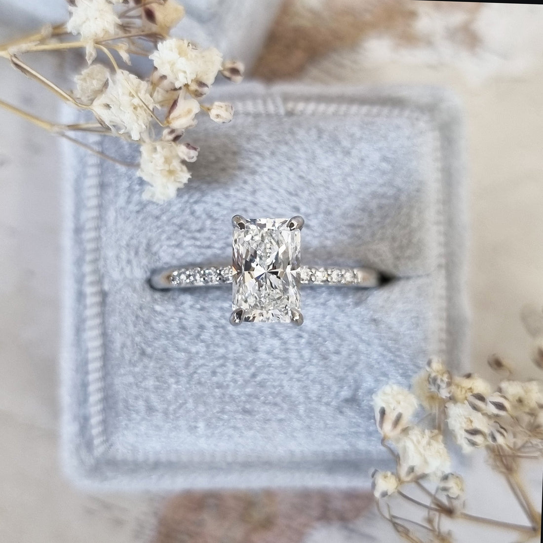 Radiant cut lab grown diamond hidden halo ring on a pave band in white metal