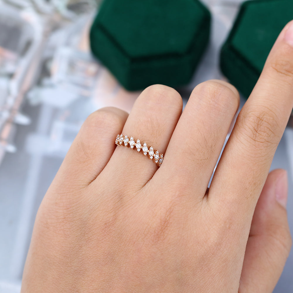 Round moissanite cluster half eternity wedding band in rose gold worn on a finger