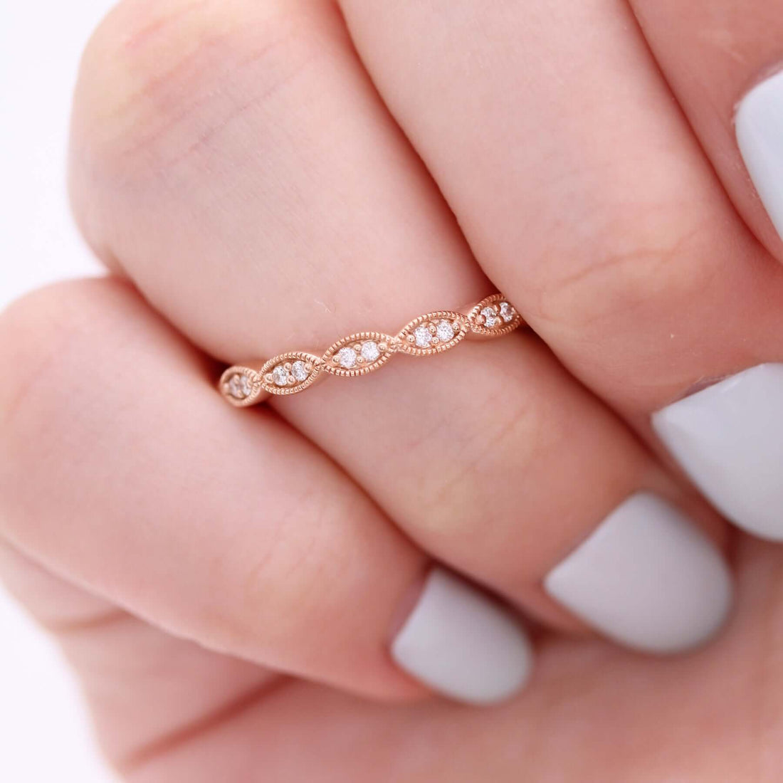 Round lab grown diamond milgrain vintage wedding band in rose gold worn on a finger