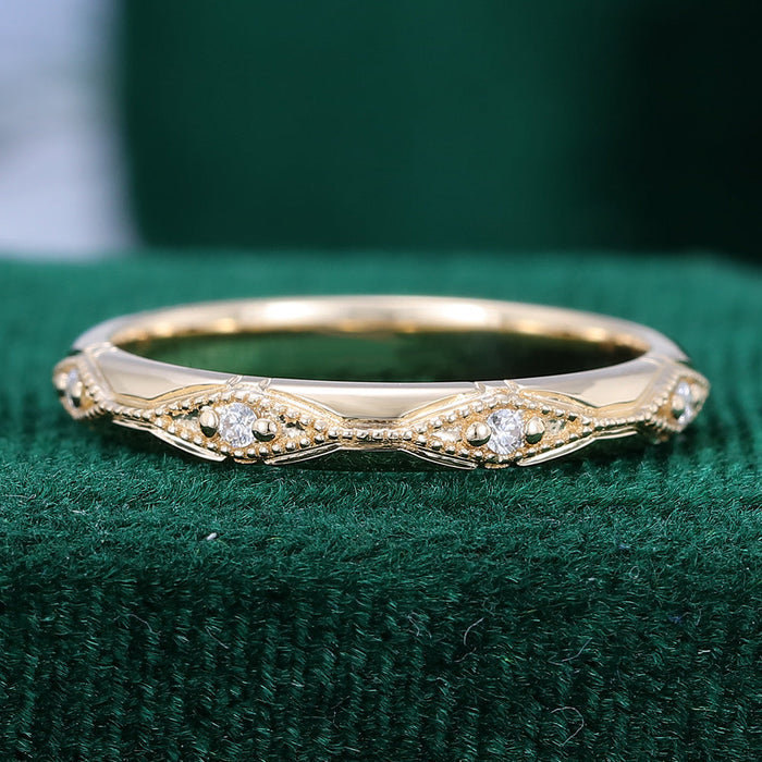 Round moissanite vintage milgrain station wedding band in yellow gold on green velvet