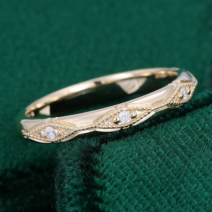 Angled view of a vintage milgrain wedding band with lozenge shaped stations and tiny round moissanite stones