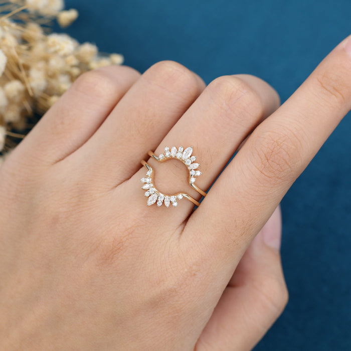 Moissanite curved enhancer guard wedding band in yellow gold worn on a finger with an open center