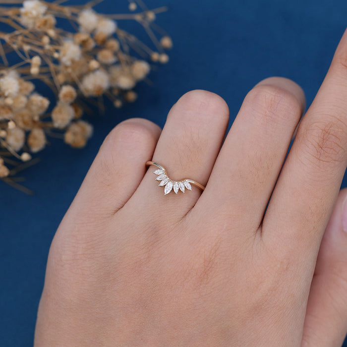 Marquise moissanite curved fan crown wedding band in yellow gold worn on a finger