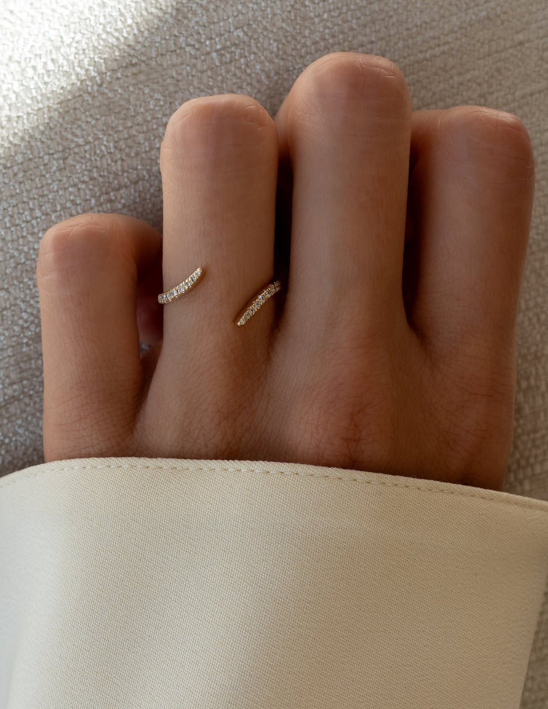 Open wrap pave wedding band with round moissanite worn on a finger