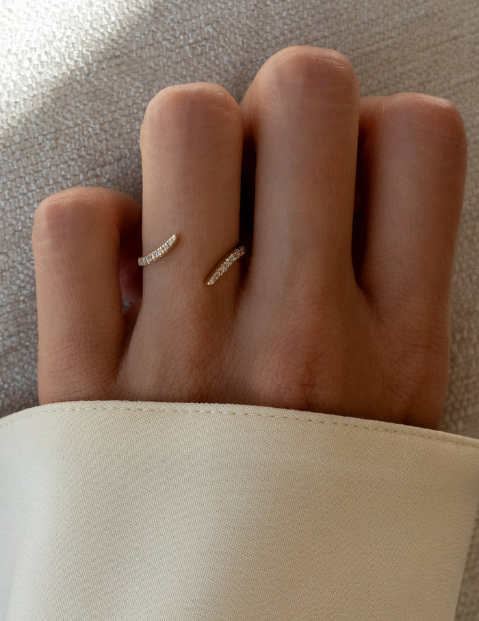 Open wrap pave wedding band with round moissanite worn on a finger