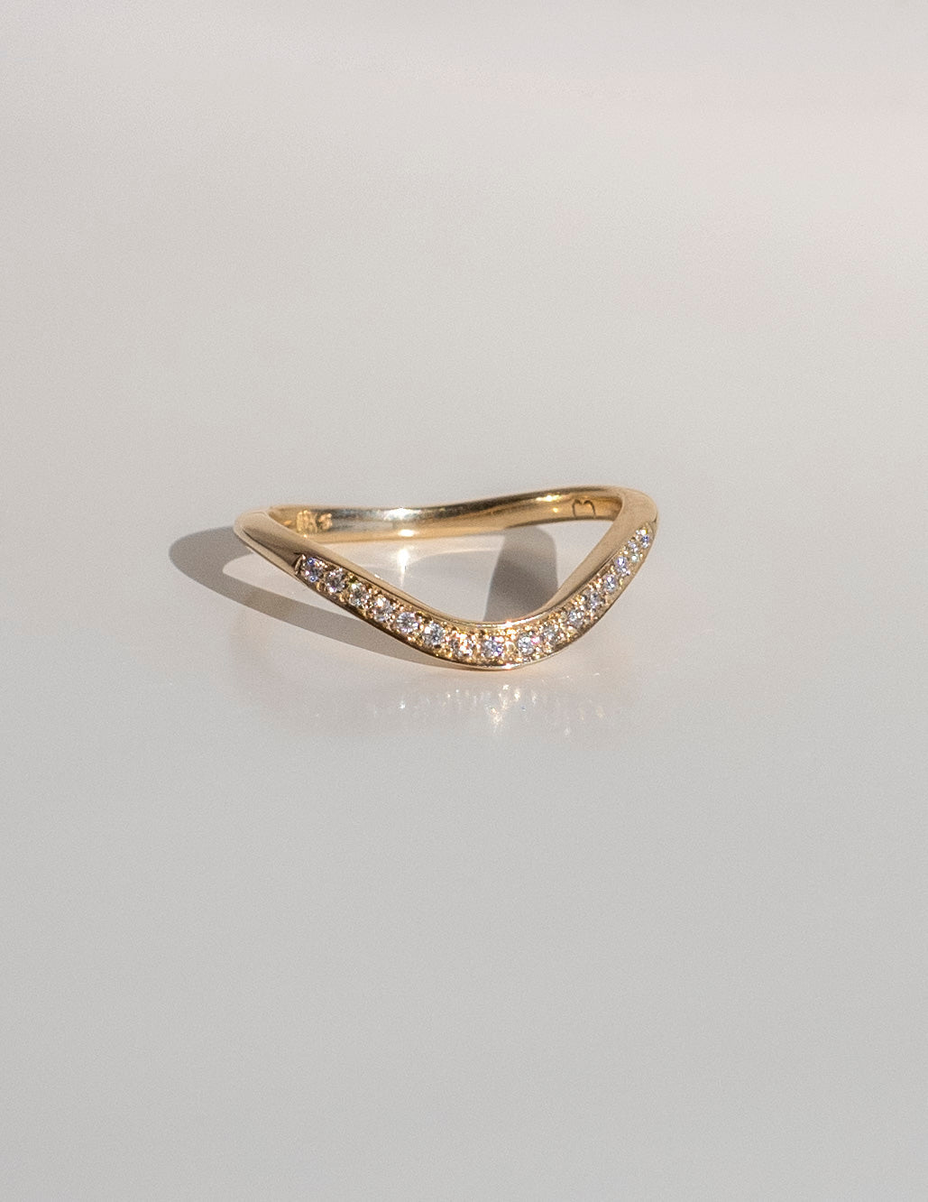 Soft curve pave wedding band in gold with round moissanite, front view