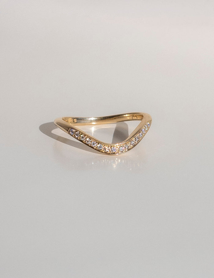Soft curve pave wedding band in gold with round moissanite, front view