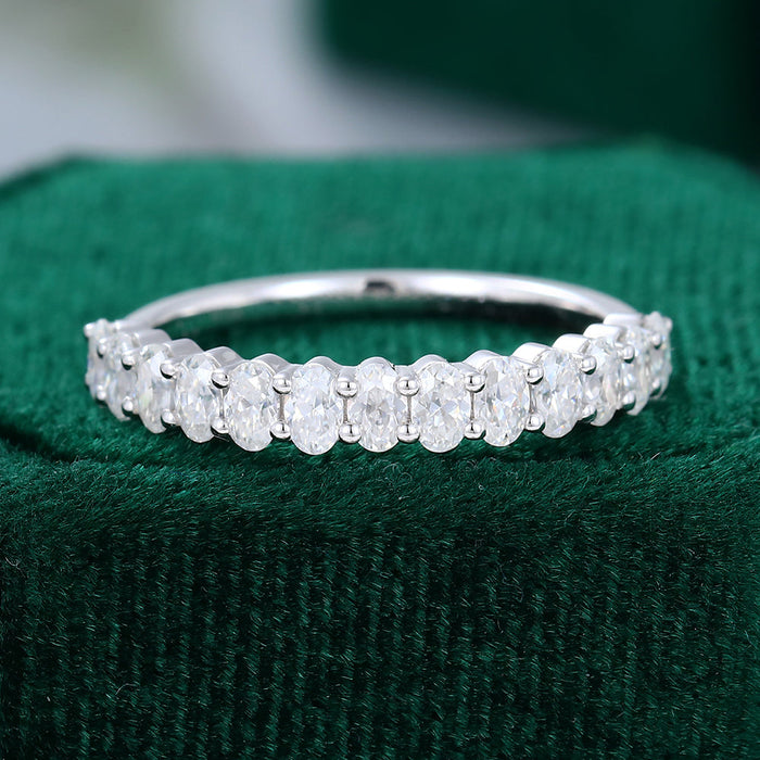 Front view of an oval moissanite shared prong half eternity wedding band in white gold