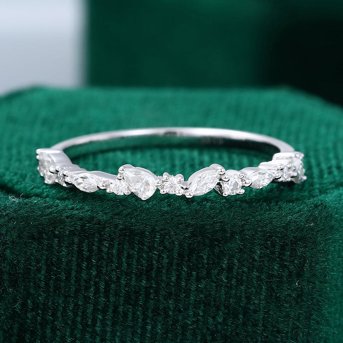 Front view of a white gold cluster wedding band with round, pear and marquise moissanite stones